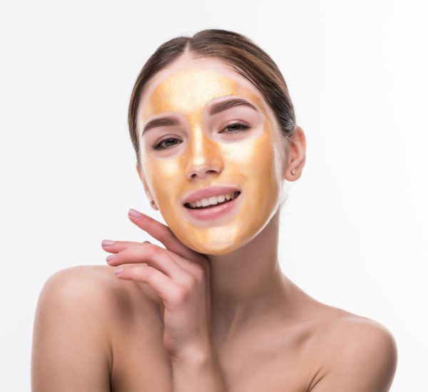 Beautiful woman with Golden mask on face skin cosmetic touch Face. Beauty Skincare and Treatment